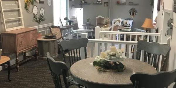 Consignment furniture showroom with tables, chairs, and home decor